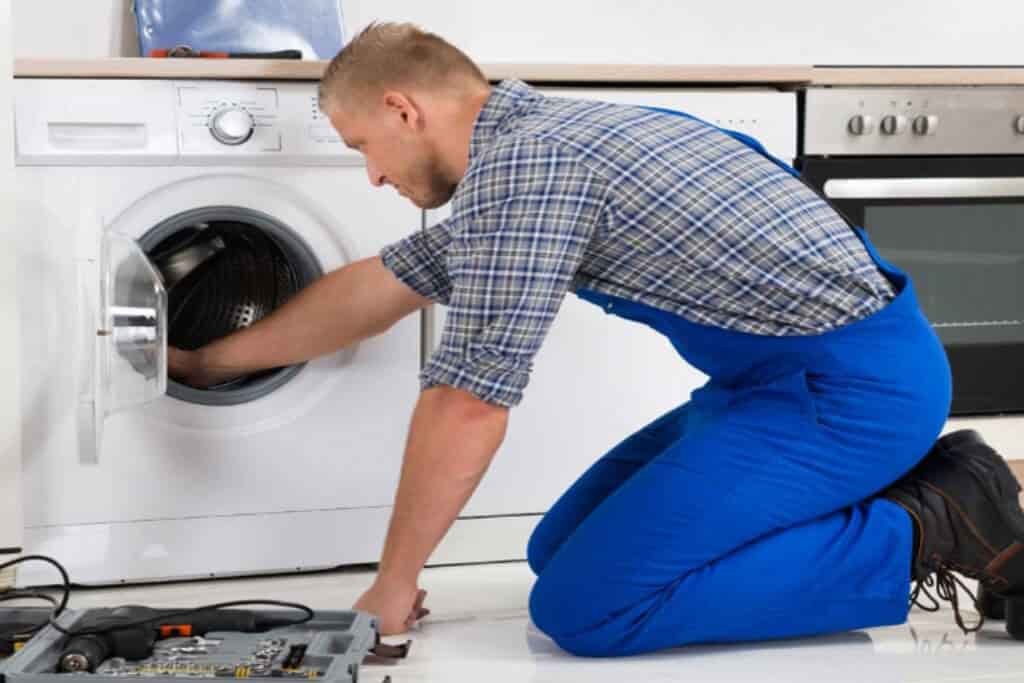 Appliance repair technician fixing the washer